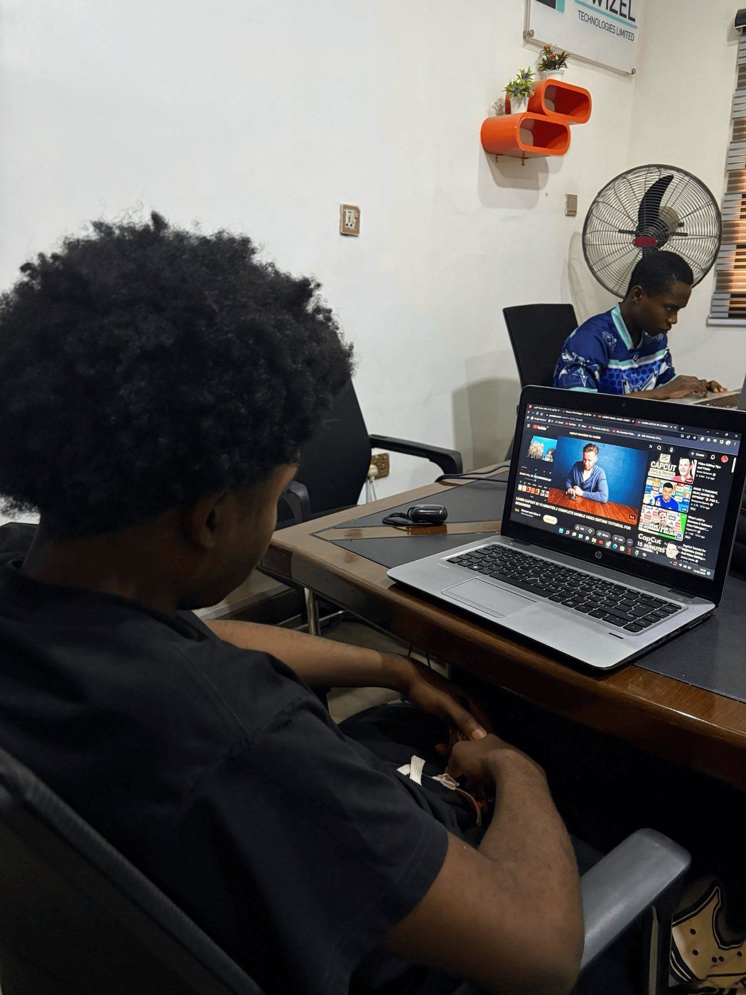 An intern working through a tutorial while the team builds around him